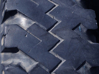 Close up old cracked dirty, full of dust. black rubber tire for truck wheel, zigzag pattern side view