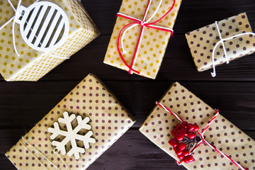 Obraz premium New Year and Christmas gifts packed and decorated on a wooden table. Flat lay. Top view