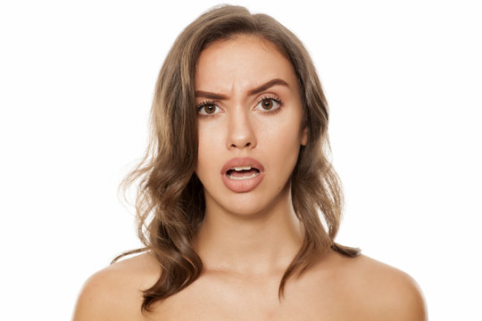Portrait of beautiful young surprised woman on white background