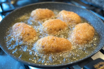 rice croquettes frying in olive oil
