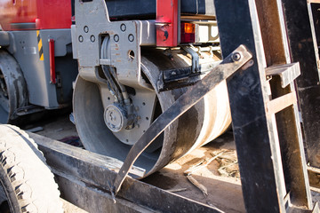heavy machine rolls a new asphalt road