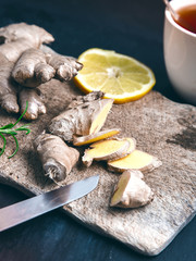 Ginger root on wooden board over dark background