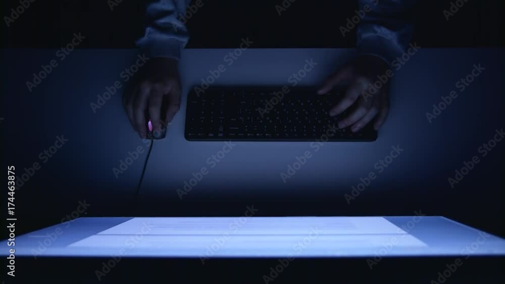 Poster manager sits at the table and prints reports. view from above