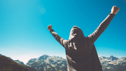 Winning and success. Victorious female person on mountain top. - obrazy, fototapety, plakaty