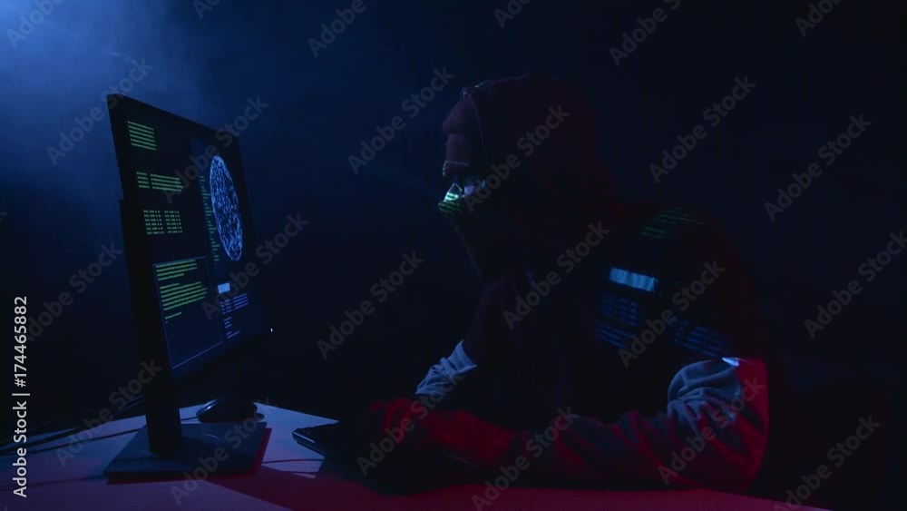 Poster man hacking computer sitting in a dark room. black smoke background