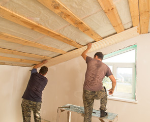 Fototapeta premium worker working on a wooden ceiling in the house