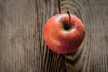 Ripe red apple on rustic dark wooden table