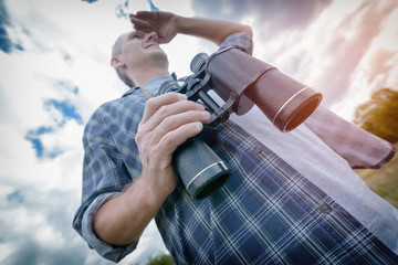Naklejka premium Man on the trail holding binoculars