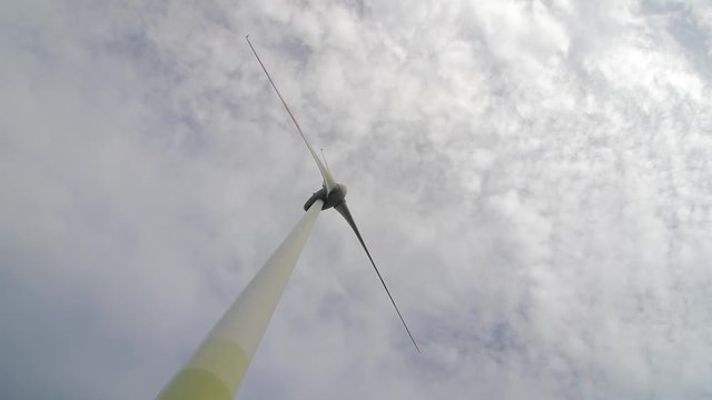 Wind turbine over stormy cloudy sky using renewable energy to generate electrical power. Renewable energy is most environmental way of power generation.