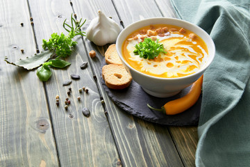 Spicy pumpkin soup with chili and garlic, served with cream and basil