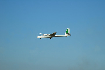 white glider on late afternoon blue sky