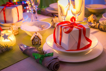 Traditionally Christmas table setting with present and candles