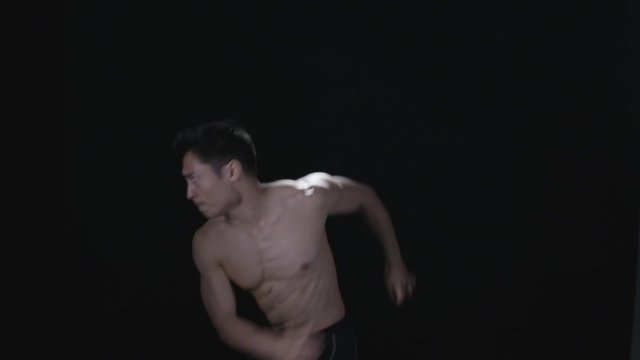  Martial arts fighter practicing kicks & punches on black background