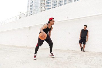 Concentrated young african sports men play basketball