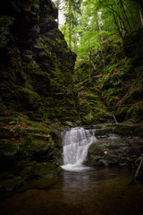 Waterfall and rocks covered with moss in the forest