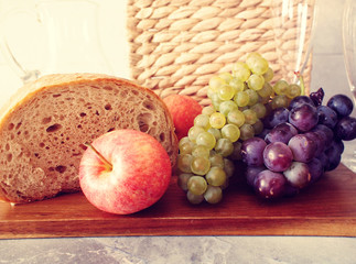 Fresh fruit and bread with the picnic basket in background