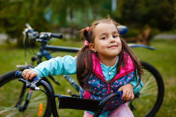 Naklejka premium Smiling little girl on a bicycle