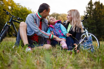 Fototapeta premium Happy family on bikes cycling outdoors active parents and kids on bicycles family sport and fun
