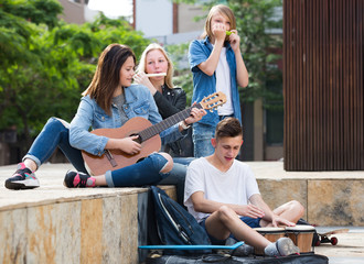 Teenagers playing music outdoors  .