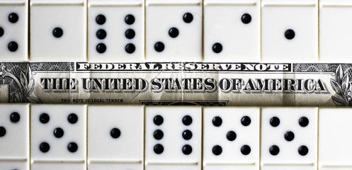 business and finance concept - dominoes and us dollar.