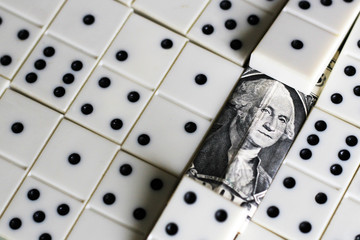business and finance concept - dominoes and us dollar.