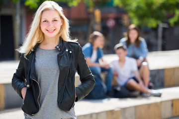 Portrait of  teenager girl standing aside from friends outdoors