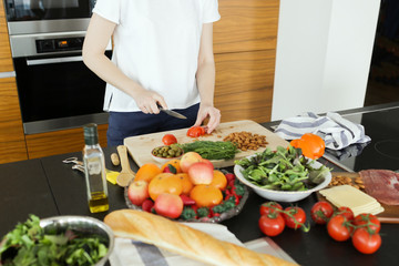 Obraz na płótnie Canvas Young woman cooking healthy food