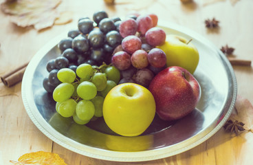 Naklejka na ściany i meble Fruits and autumn leaves. Apples and grapes.
