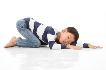 Fototapeta na wymiar Asian cute boy sleeping while lay down on floor. White background.