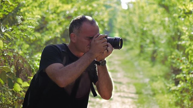 Nature photographer taking photos and zooming out in the green valley
