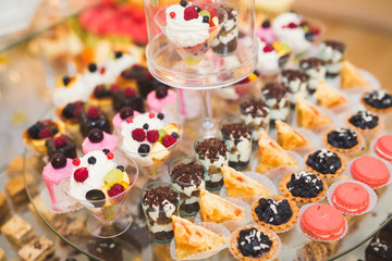 Delicious sweets on wedding candy buffet with desserts, cupcakes