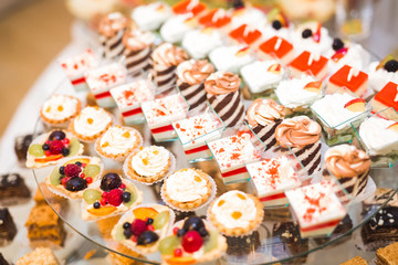 Delicious sweets on wedding candy buffet with desserts, cupcakes