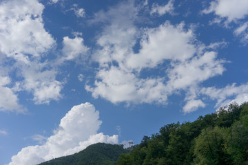 mountain landscape on background of blue cloudy sky and a view of the cable car