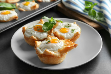 Tasty baked eggs in dough on plate