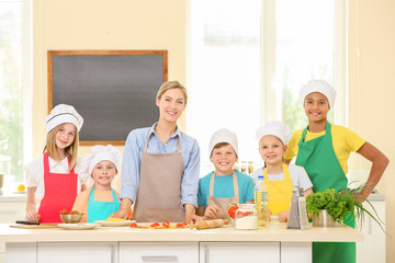 Group of children and teacher in kitchen during cooking classes