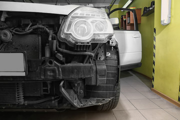 Damaged car in repair shop, closeup