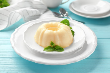 Plate with delicious vanilla pudding on wooden table