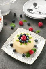 Delicious vanilla pudding with berries on table