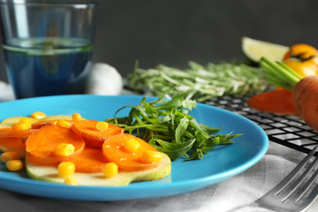 Carrot salad with corn and arugula on kitchen table