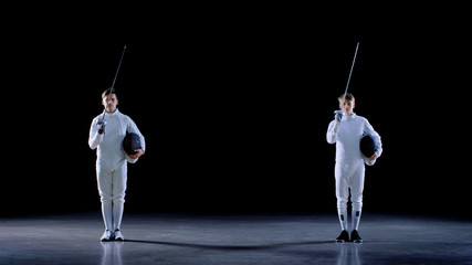 Two Young Professional Fencers Greet Audience, and Preparing for Fighting Match. Shot Isolated on...