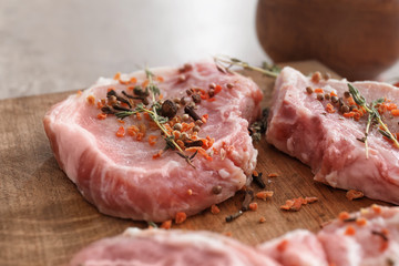 Wooden board with fresh raw meat, closeup