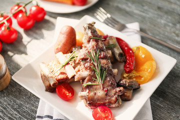 Plate with grilled ribs on table