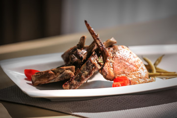 Plate with grilled meat on table