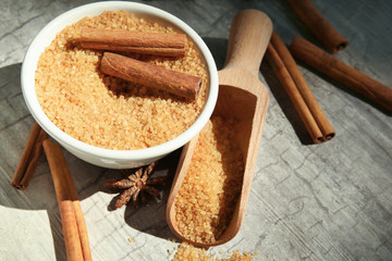 Composition with cinnamon sugar and sticks on wooden background