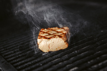 Medium rare grilled meat on hot cook. Steak with smoke