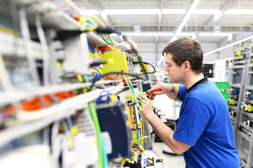 Montage von Elektronik im Maschinenbau - Arbeiter in einer Hi Tech Fabrik // Assembly of...