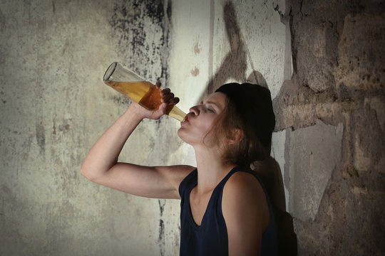 Woman drinking alcohol in abandoned building