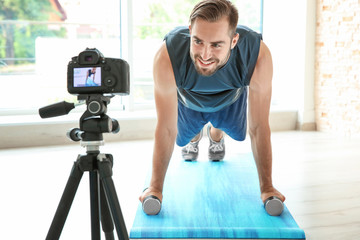 Young sports blogger recording video on camera at home