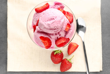 Glass dessert bowl with tasty strawberry ice-cream on table