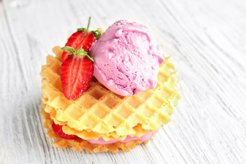 Waffles with tasty strawberry ice-cream on table